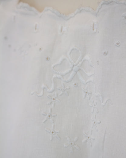 Close up of wreath embroidery on white shirt