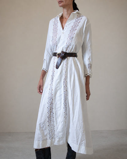 Woman wearing white dress with lace detailing and brown belt