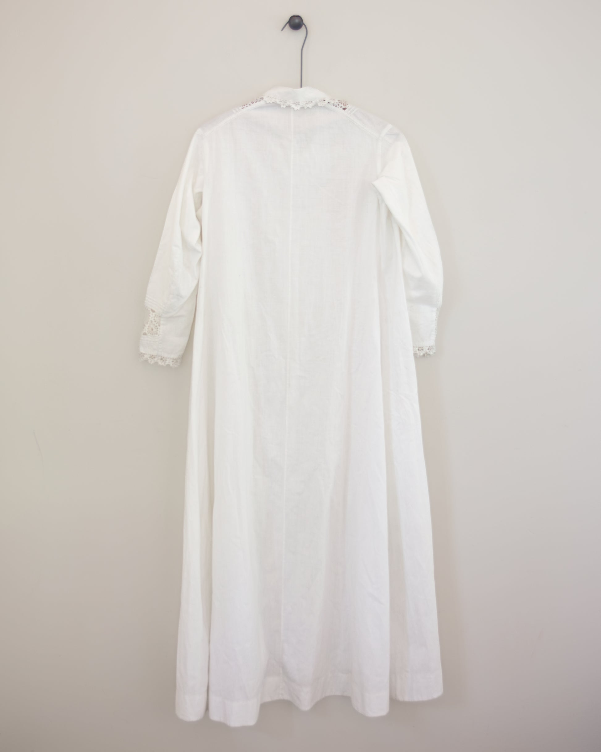 Back of white dress with lace detailing on hanger