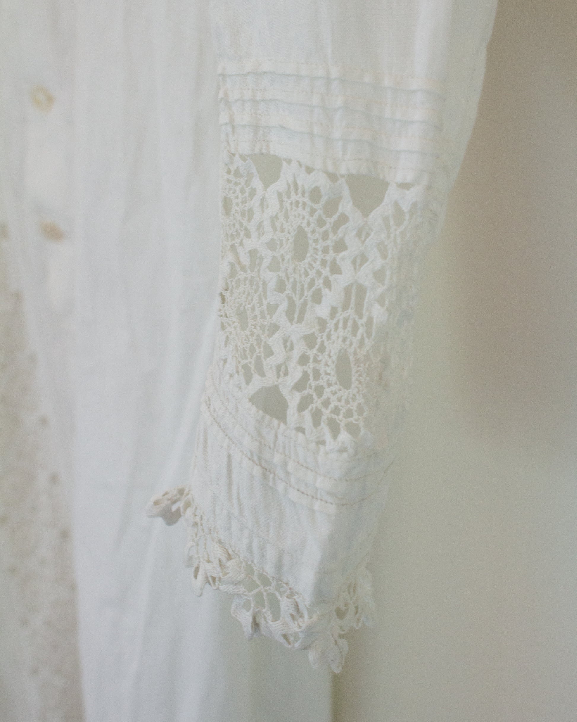 Sleeve of white dress with lace detailing