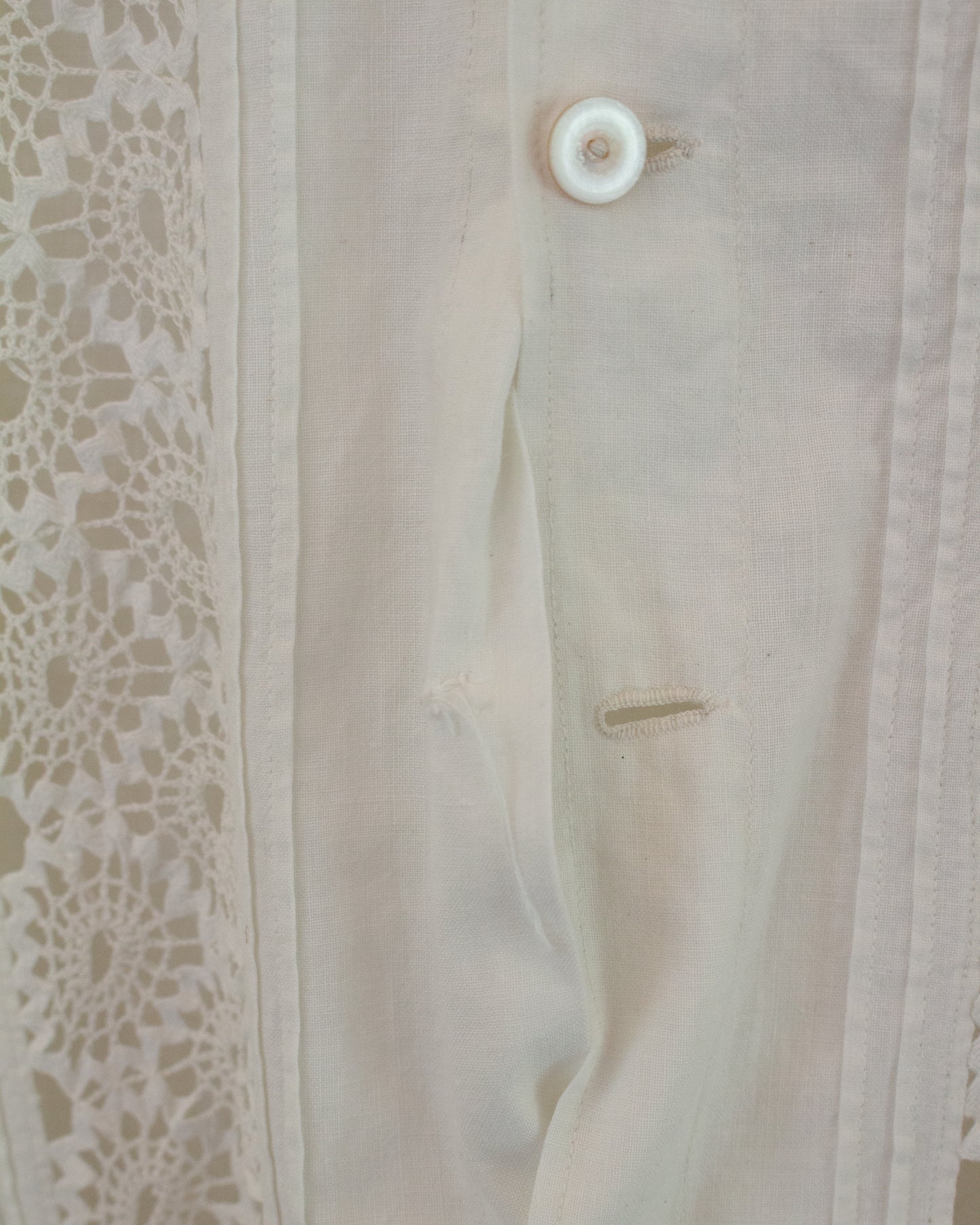 Missing button on white dress with lace detailing 