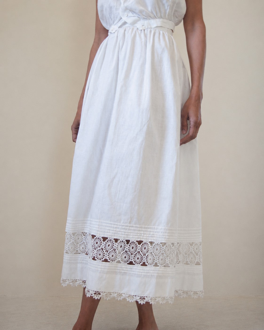 Woman wearing white skirt with lace detailing along bottom