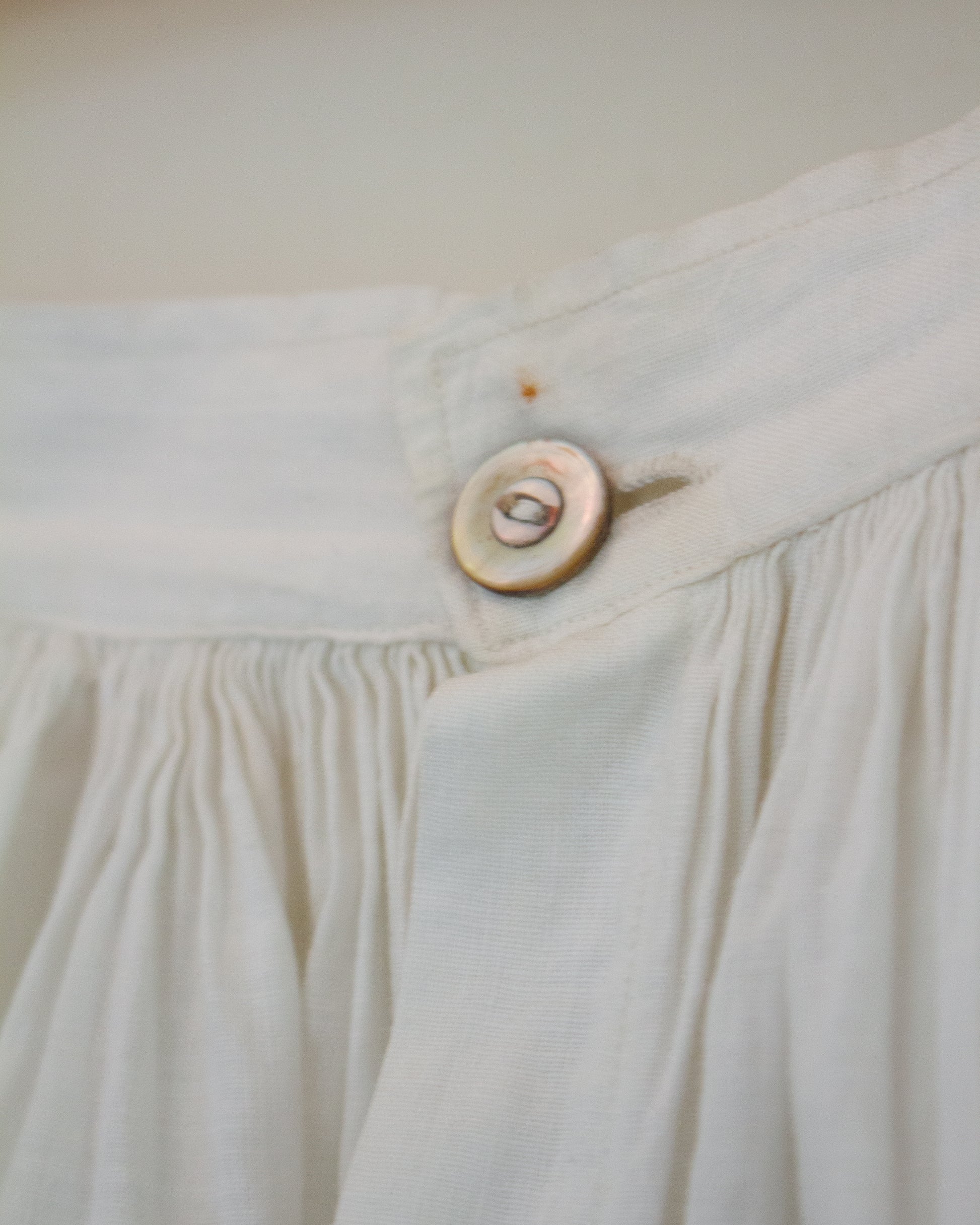 Button on skirt with small mark above it