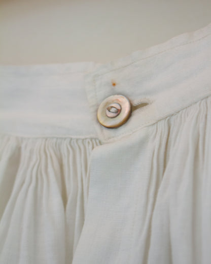 Button on skirt with small mark above it