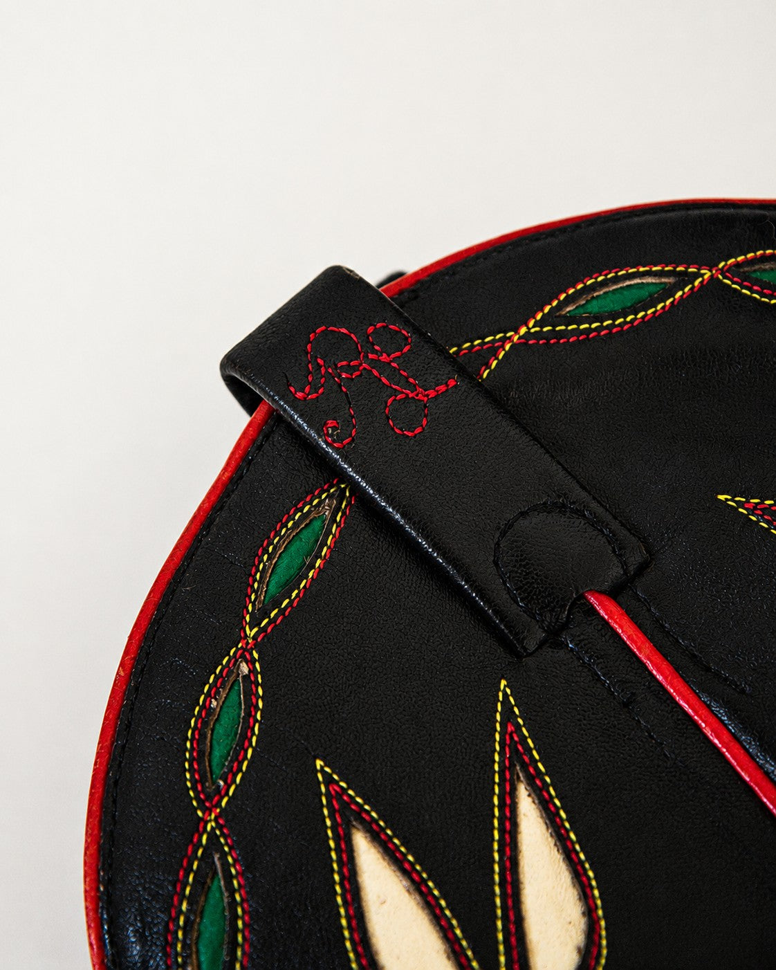 Close up of cursive RL logo on black cowboy boots with multi-colored inlay