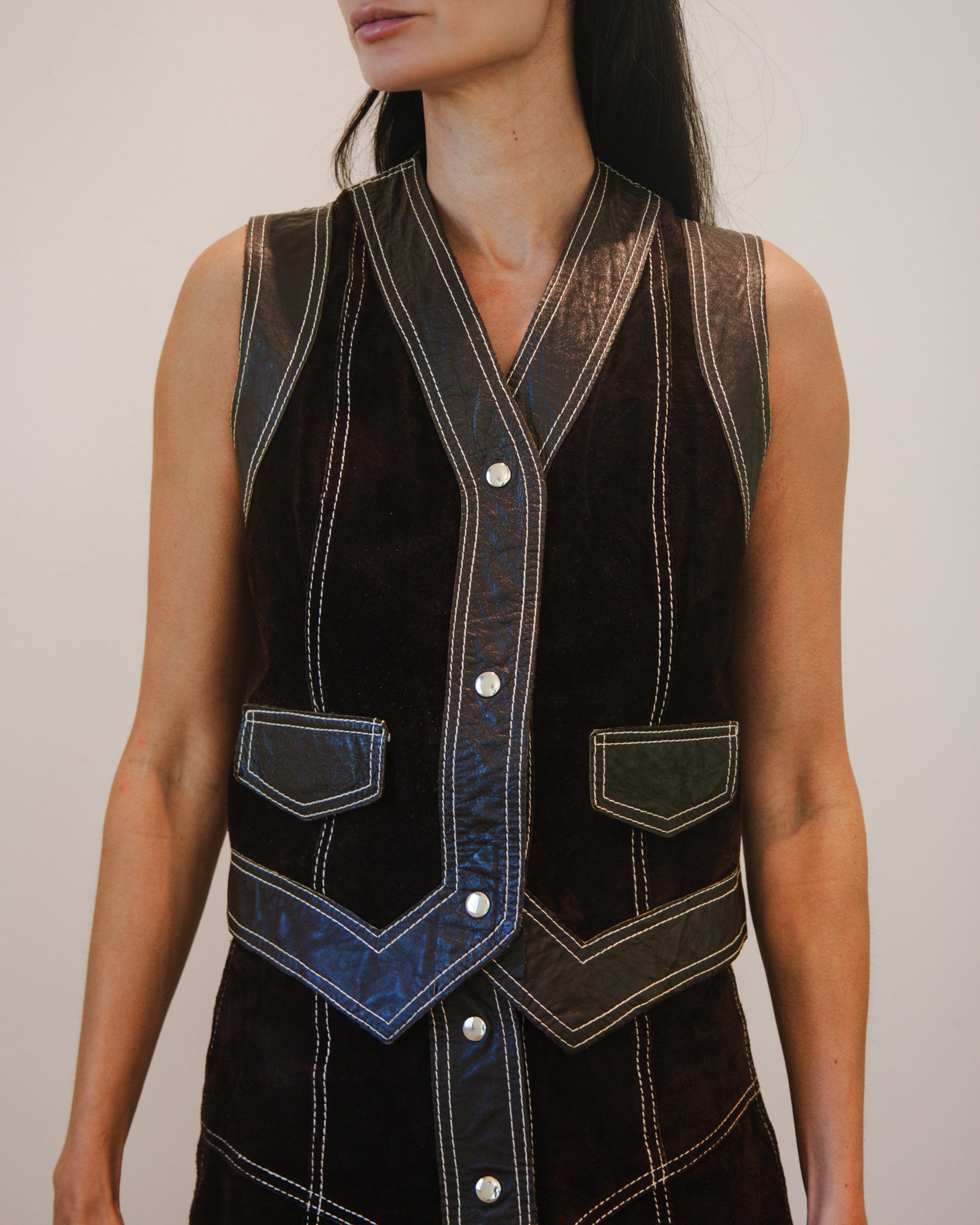 Front top view of person wearing a brown leather skirt and vest set 