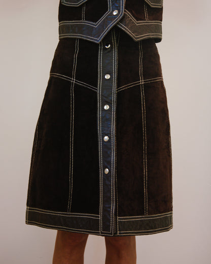 Brown leather skirt with white stitching on a plain background