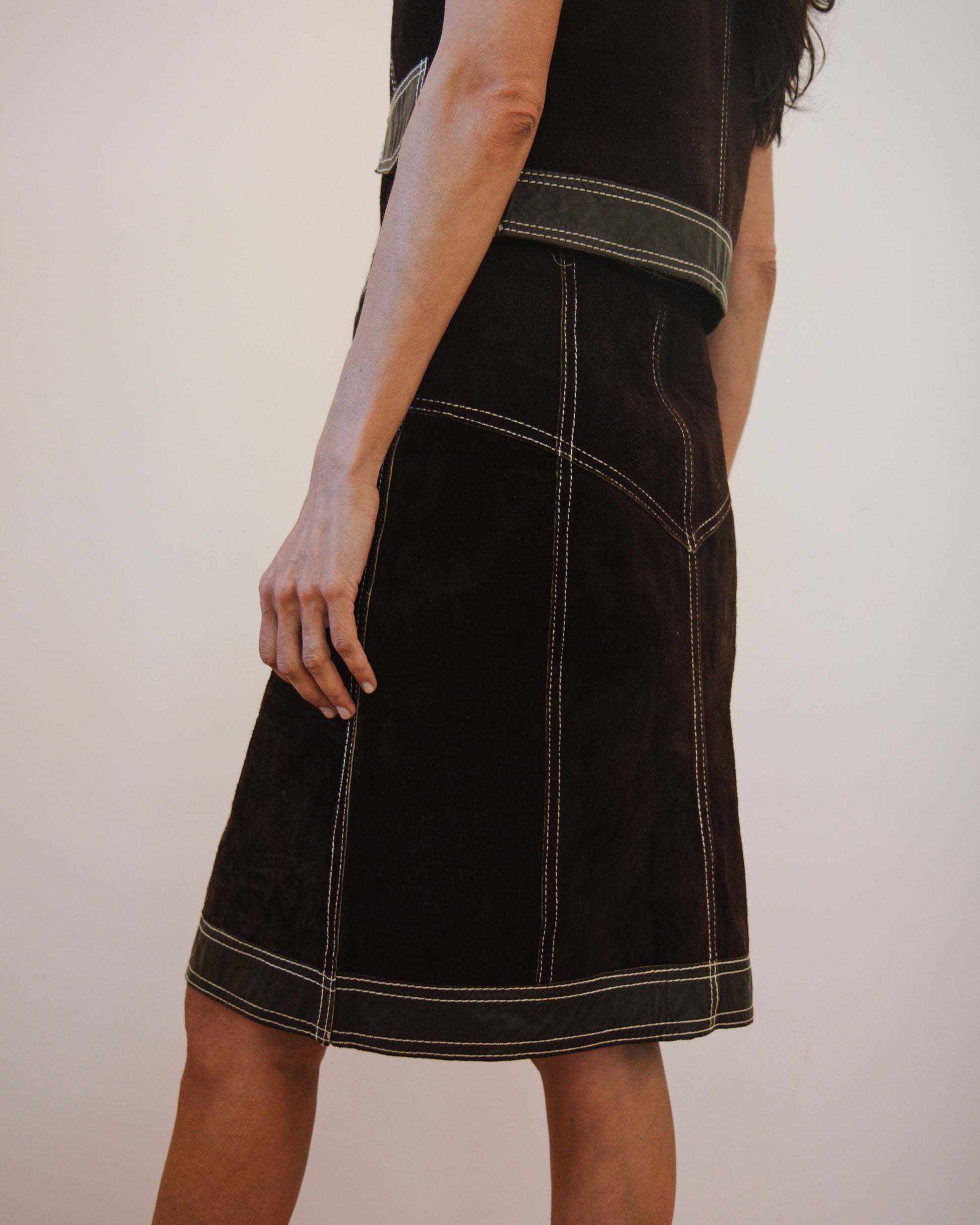 Back view of person wearing a brown leather skirt and vest set 