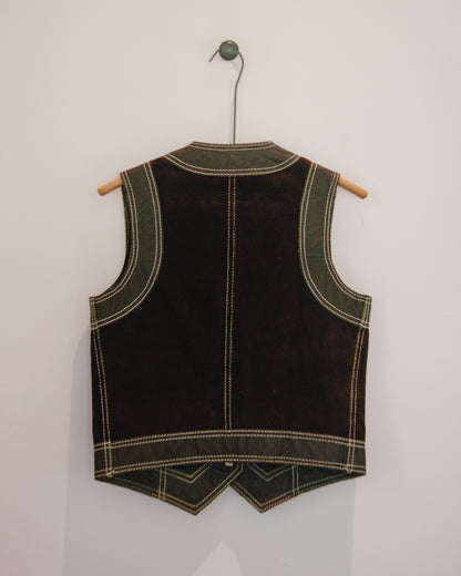 Back view of brown leather vest on a hanger against a white wall