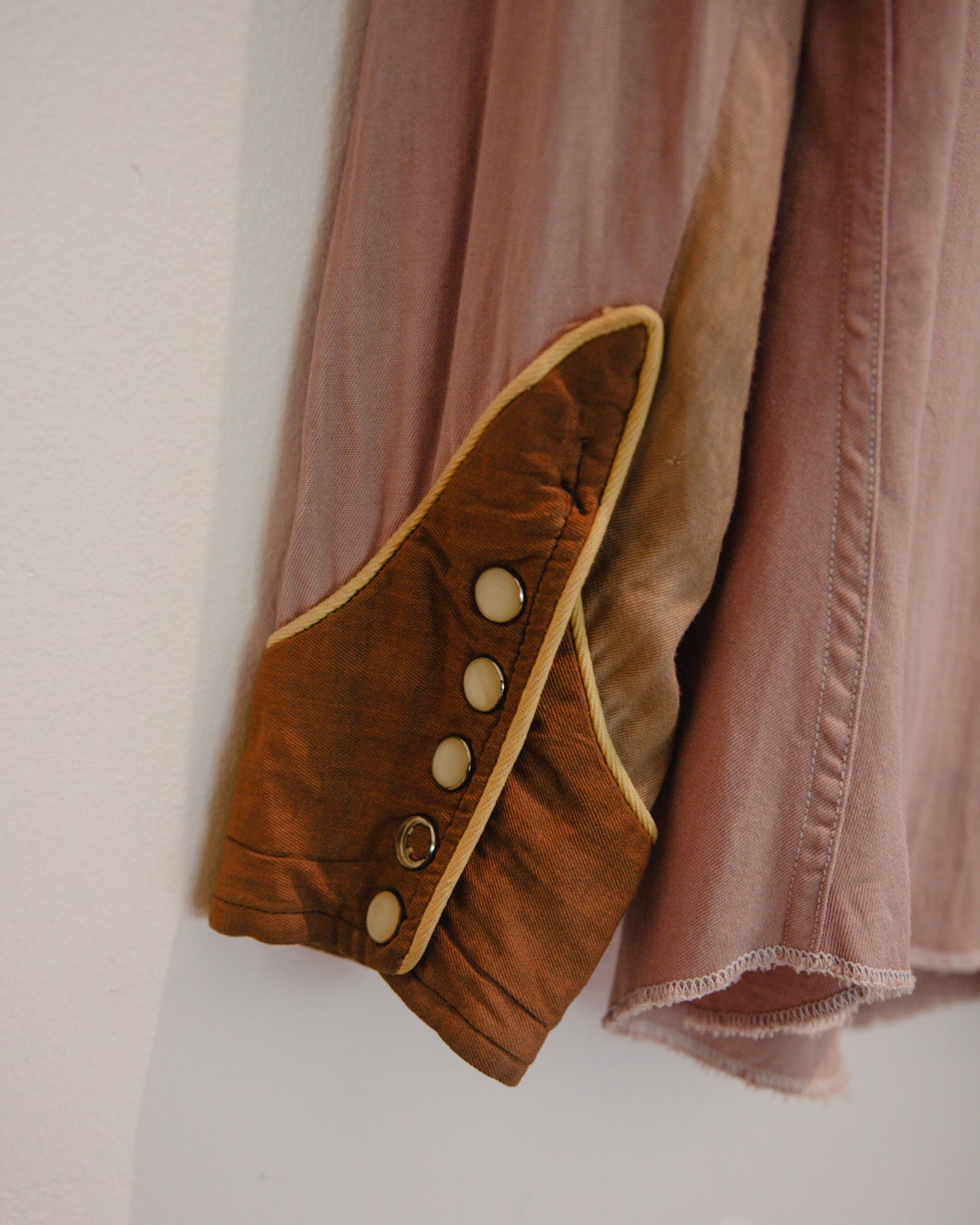 Brown jacket with button details on a plain background