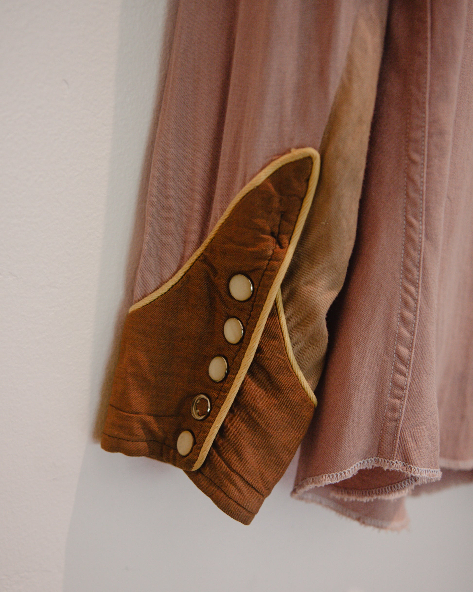 Brown jacket with button details on a plain background