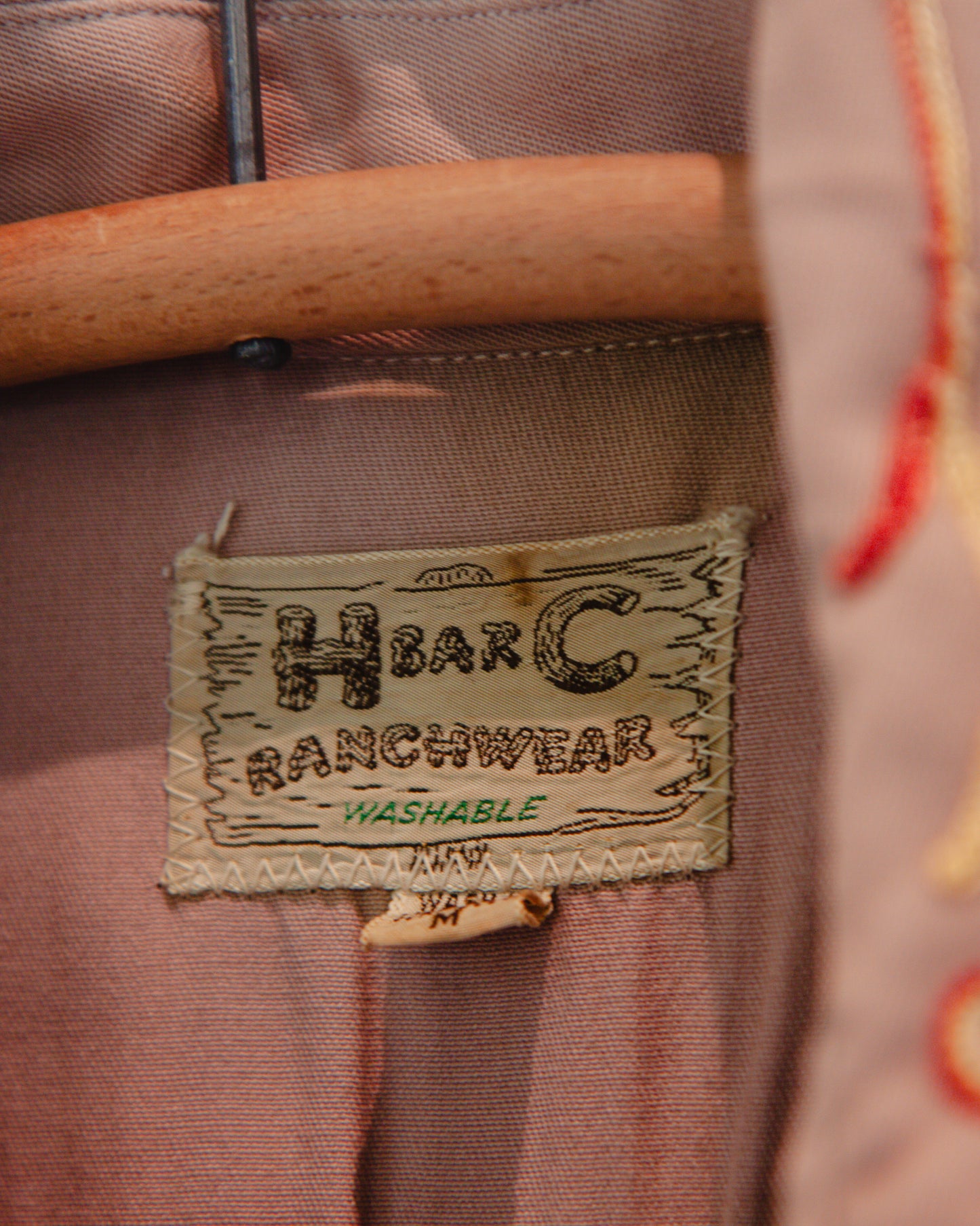 Label on a piece of brown fabric with 'HbarC Ranchwear' branding.