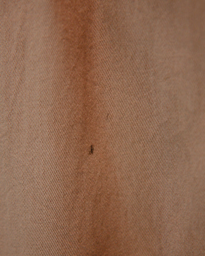 Close-up of brown fabric texture with a small dark spot