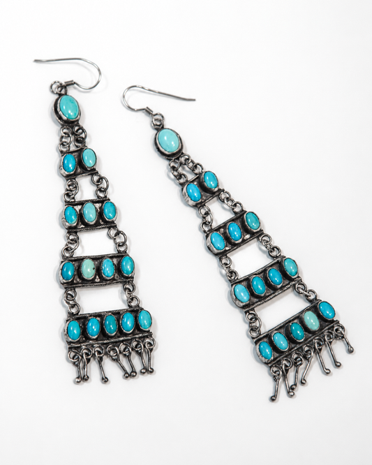 Pair of turquoise and silver earrings on a white background