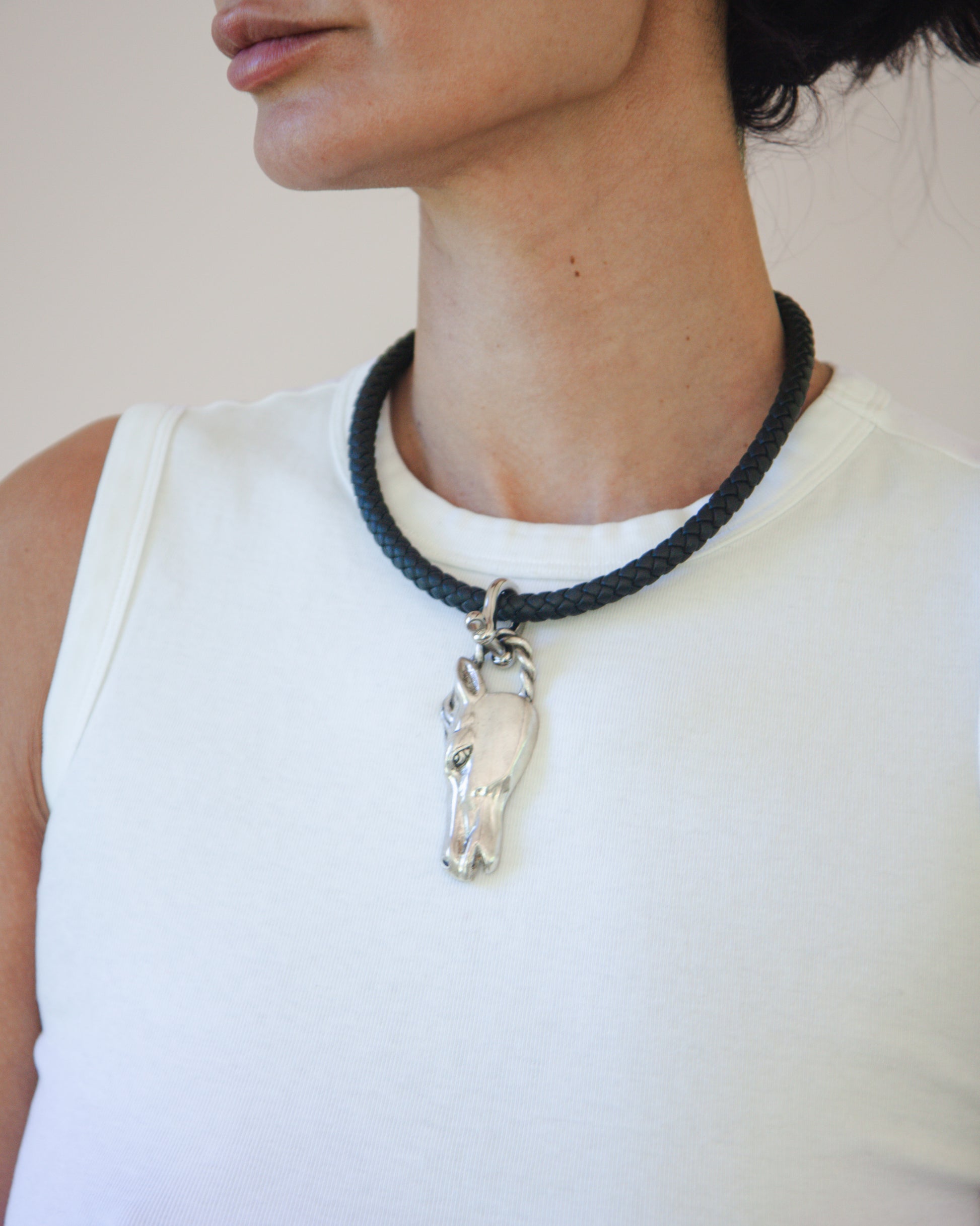 Woman wearing horse head pendant on black cord choker necklace