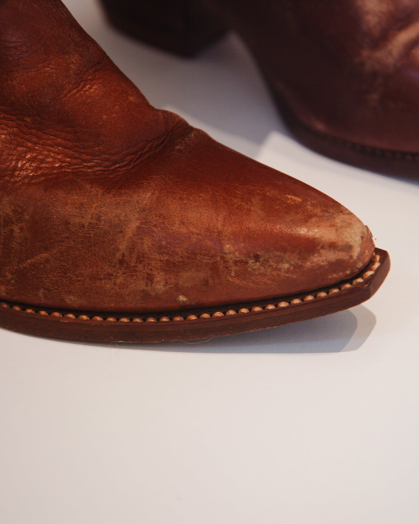 Close-up of a brown leather boot on a white background