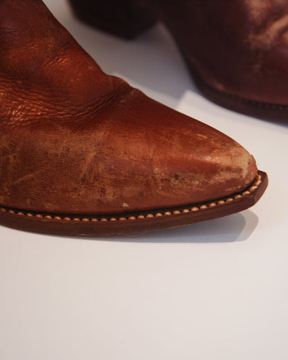 Close-up of a brown leather boot on a white background