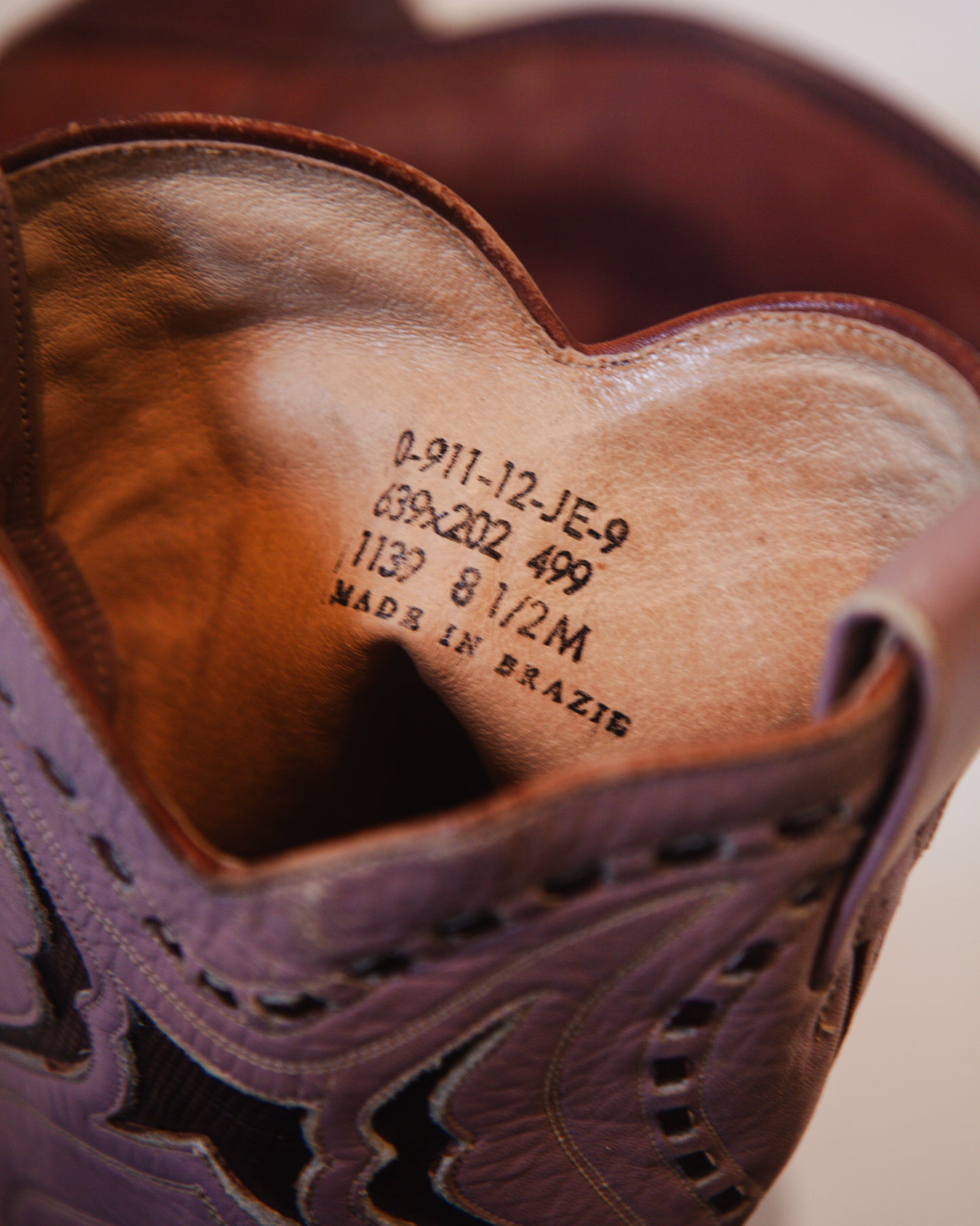 Close-up of a brown leather shoe with text on the insole, showing 'Made in Brazil'.