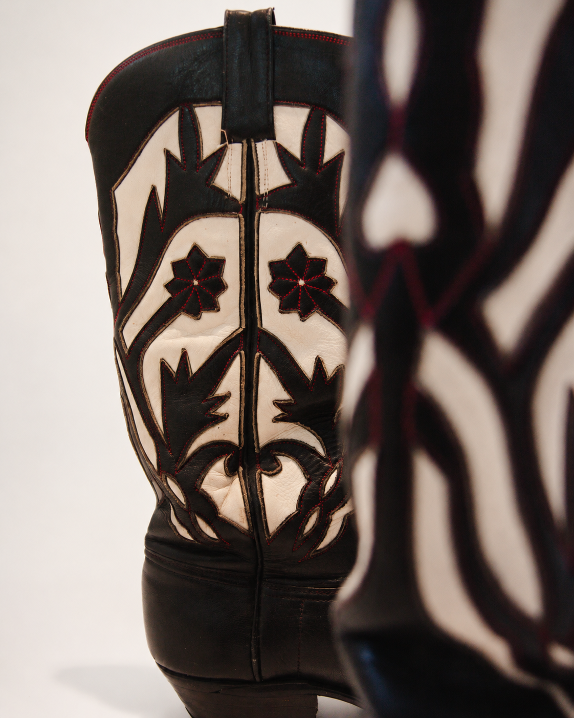 Black and white patterned cowboy boot on a light gray background