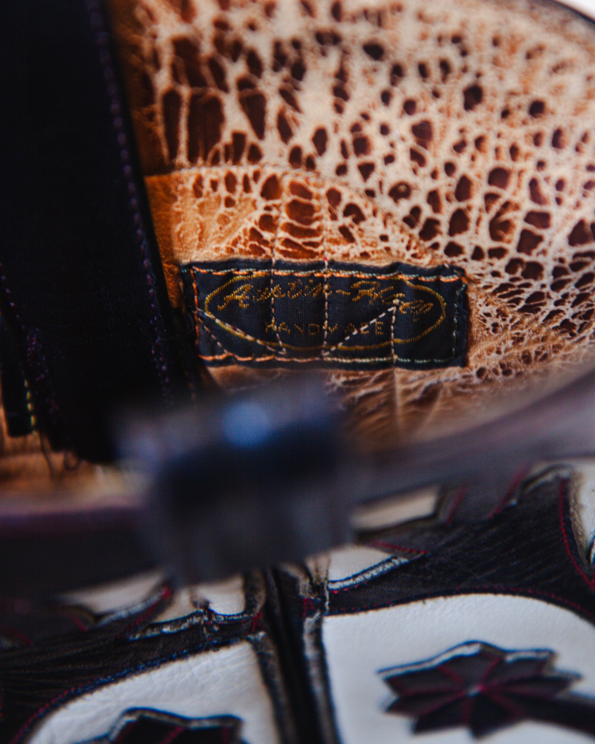 Close-up of a textured fabric surface  inside the cowboy boot with a brand label.