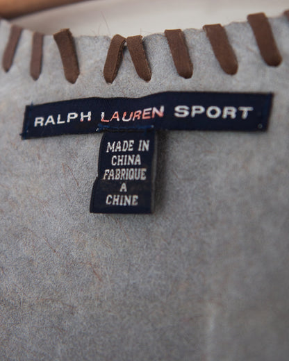 A brown faux fur vest with cowhide accents and whipstitching, detailed view on Ralph Lauren Sport tag.