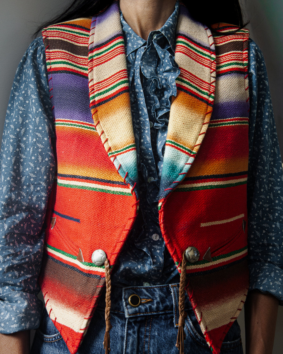 A sleeveless woven vest with a colorful serape-style striped pattern on a woman.