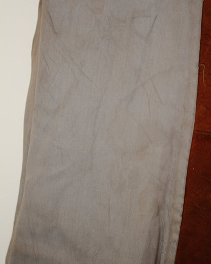 A close-up of a light gray fabric garment, showing the texture and folds.