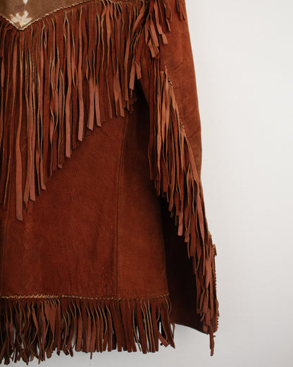 Close-up of a brown suede fringe garment, showing the texture of the suede and the layered fringe details against a plain white background.