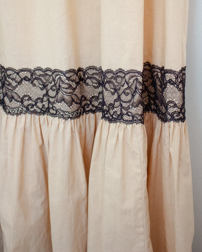 Close-up of a cream-colored fabric panel with a wide black lace band across the middle.