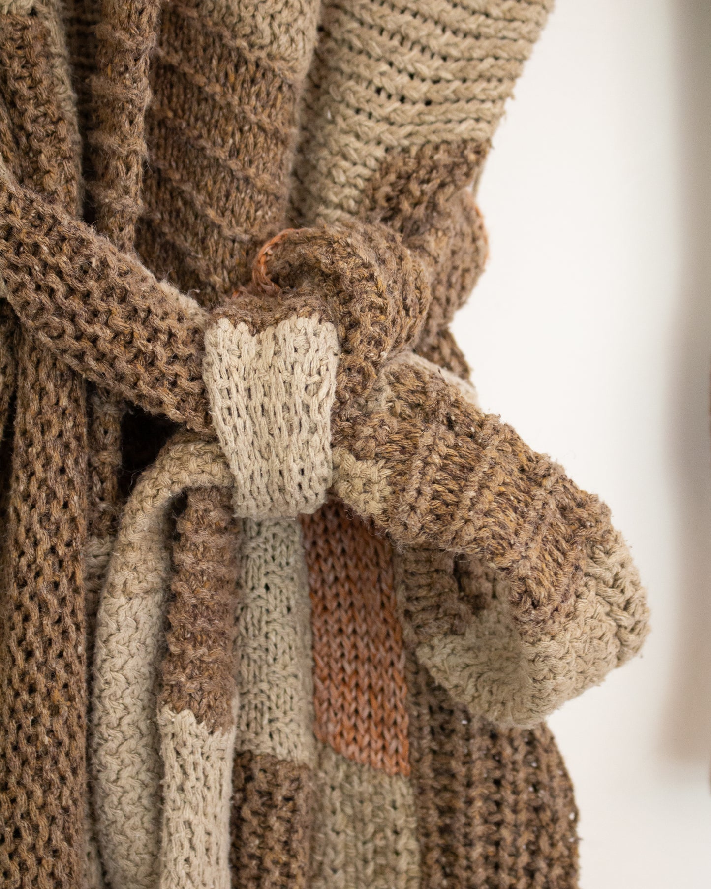 Cardigan tie on brown knit garment. 
