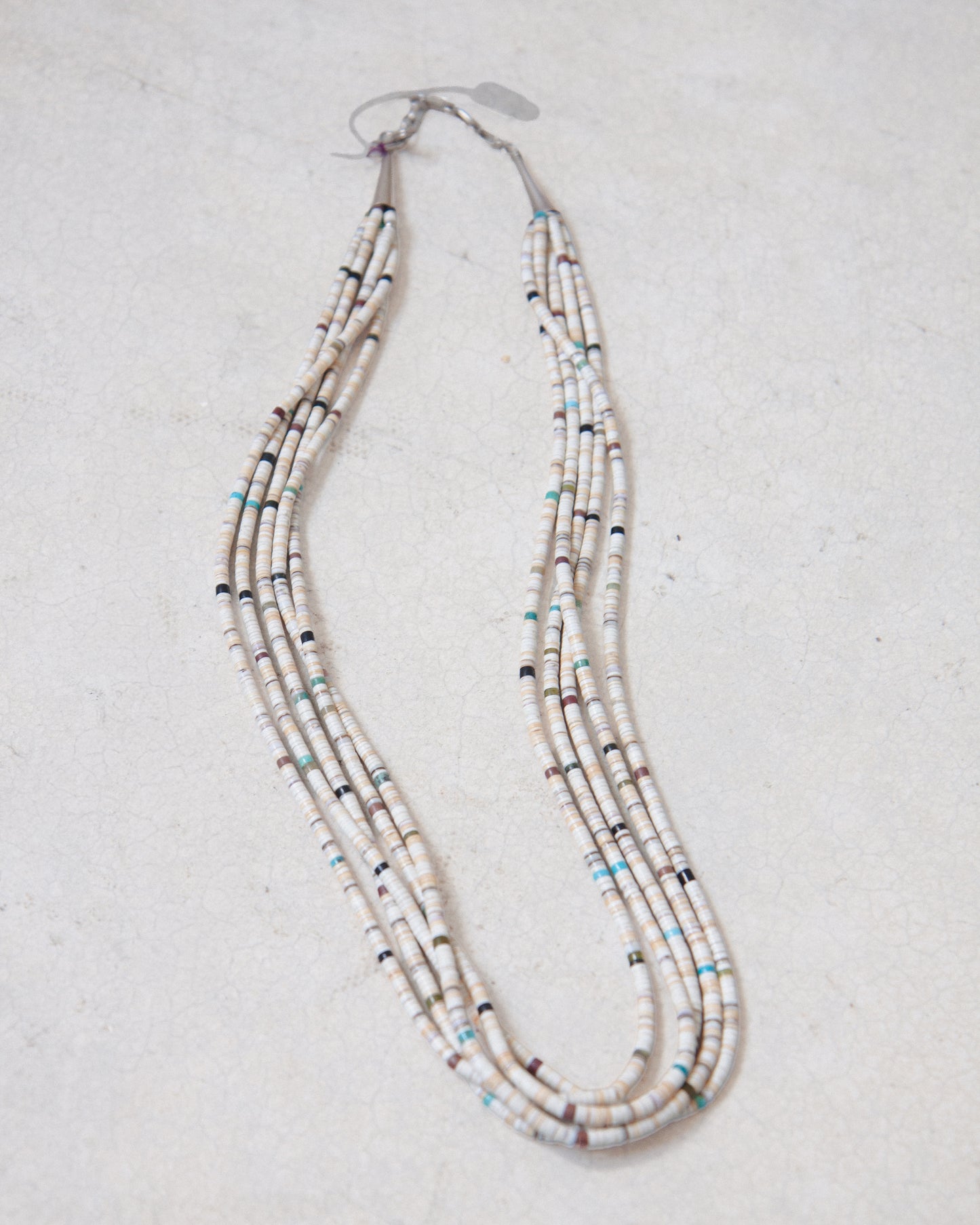 Vintage 5-Strand Santo Domingo Heishi necklace laying on white surface.