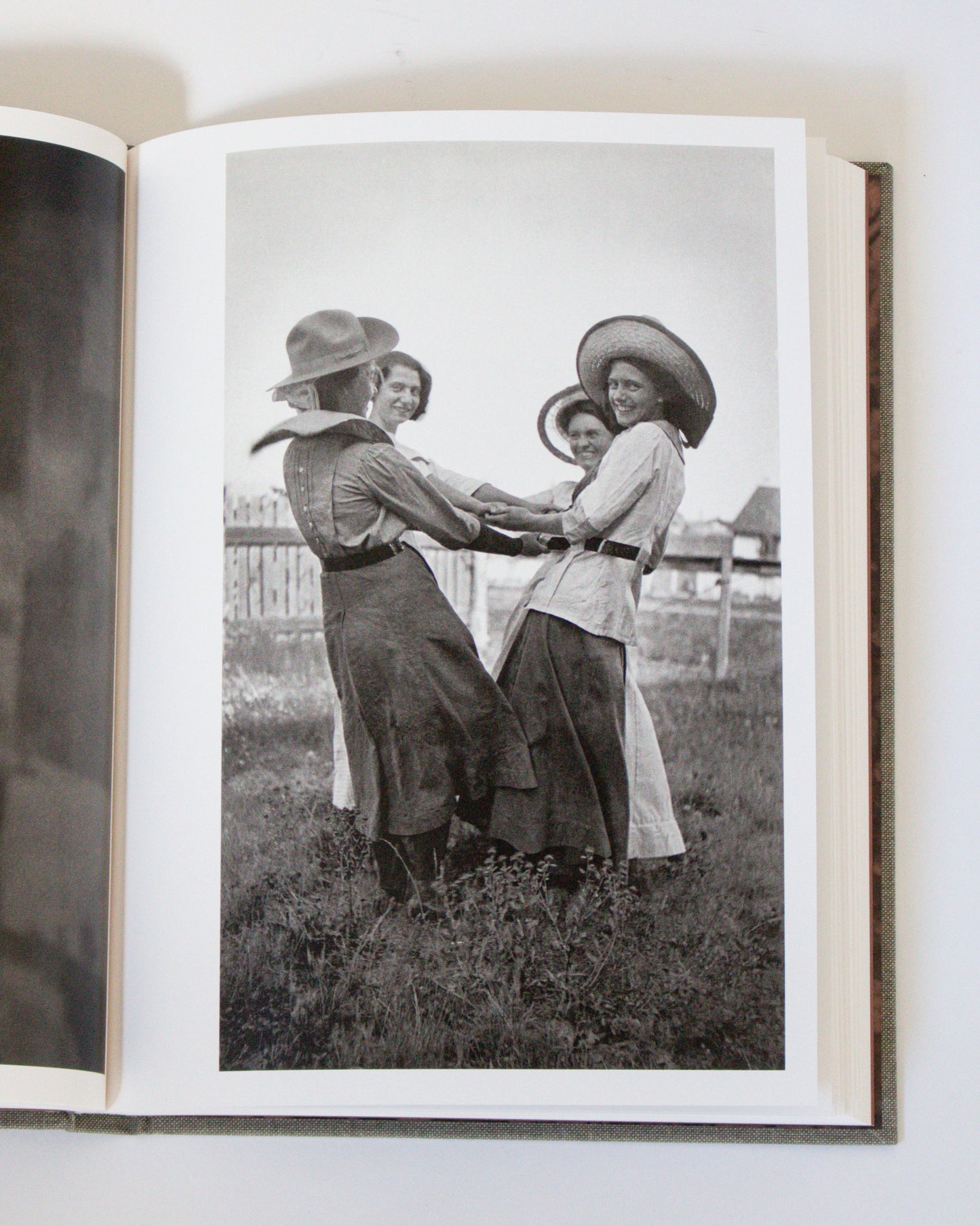 Open book showing a black and white photograph of four women in a field.